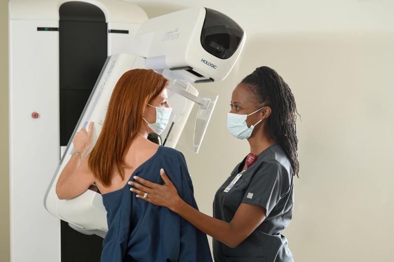 Nurse helping patient with mammogram.